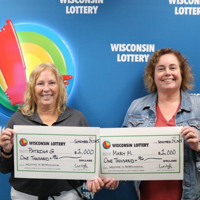 Two women Smiling holding winner checks